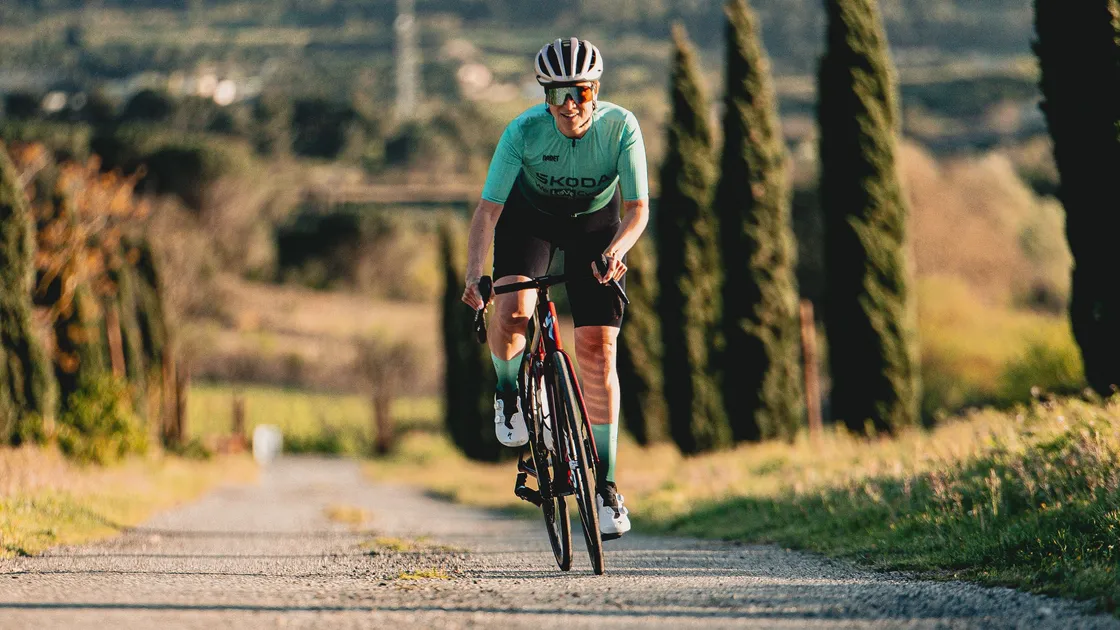 Cycliste en tenue estivale avec lunettes de soleil et casquette fine sous le casque (20° et plus)